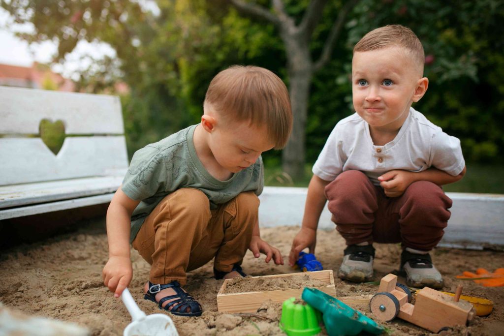 two childs playing in the sand