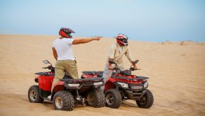 two men on atvs in the desert