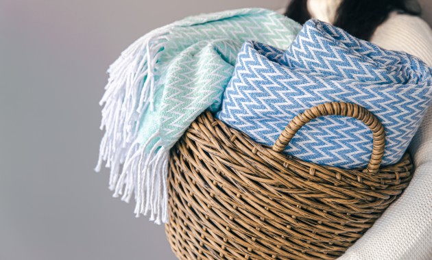 light blue and white rug that is freshly washed with detergent and fabric softener along with it. The rugs are placed in a basket.