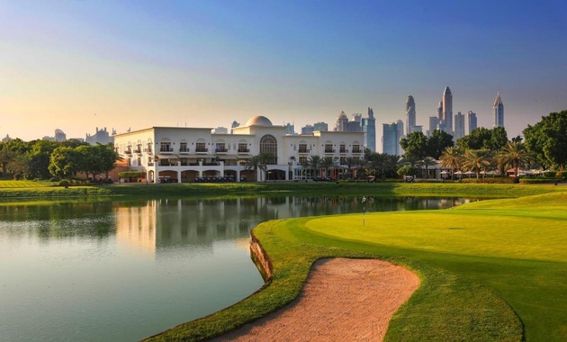 a golf course with a large building and a lake