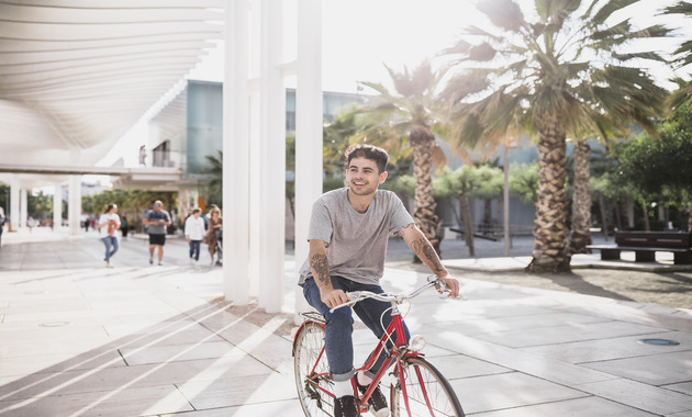 young boy riding bike in city park