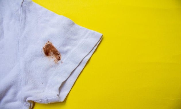 a white shirt on yellow background with chocolate stain