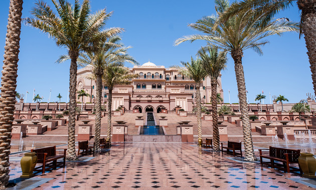 amazing view of a hotel building with so many palm trees