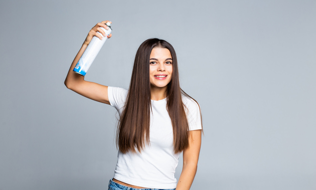 a girl is holding a hair spray 