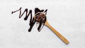 a spoon full of chocolate is laying on a white table