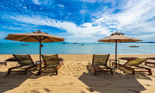 clear sky, blue sea water, umbrellas and chairs to rest at the beach in dubai 