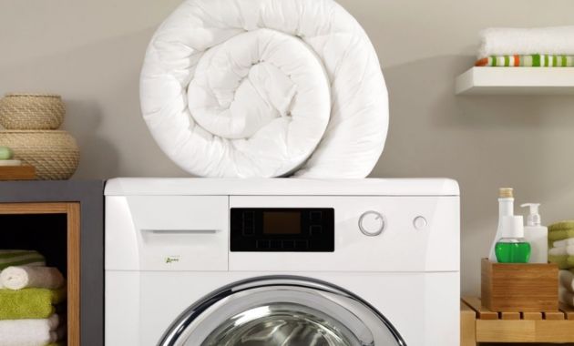 a white comforter placed over a white washing machine 