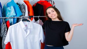 a girl is holding a white shirt