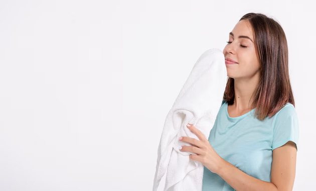 a girl is holding white freshly washed shirt