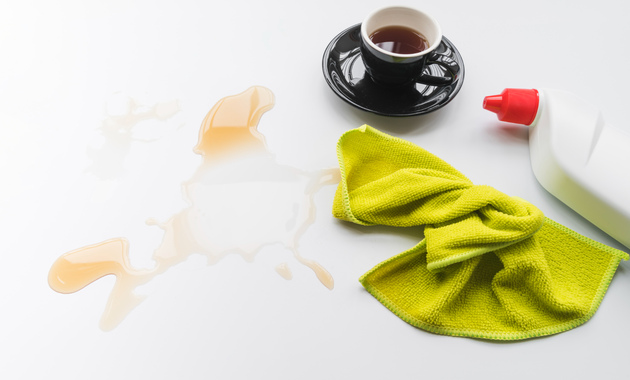 a cup of tea and a rag on a white surface