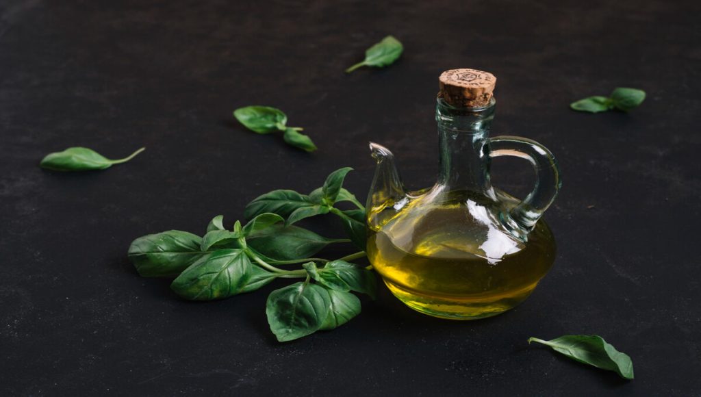 bottle of neem oil along with neem leaves