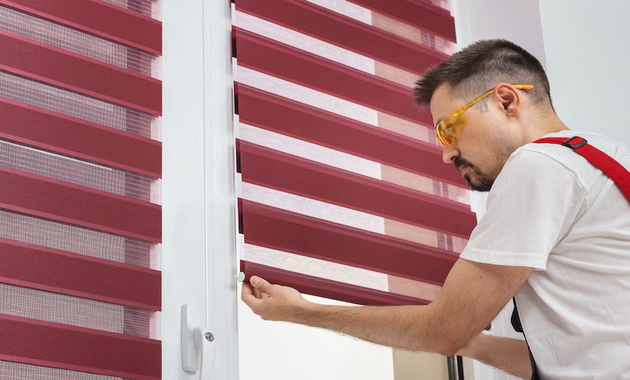 a  man is nstalling window blinds