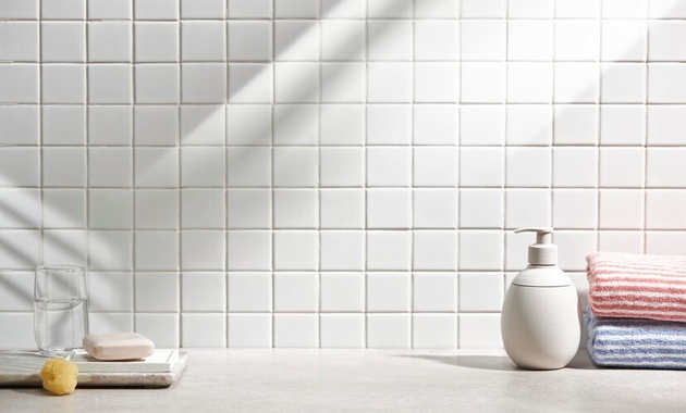 white bathroom tiles with towels placed besidee it